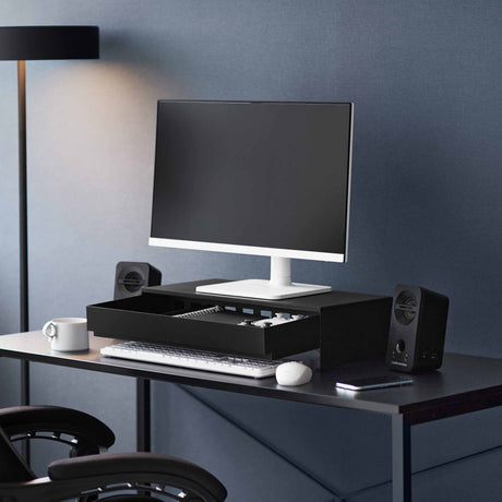 Sort skjermstativ med skuff plassert på skrivebord for ryddigere arbeidsplass