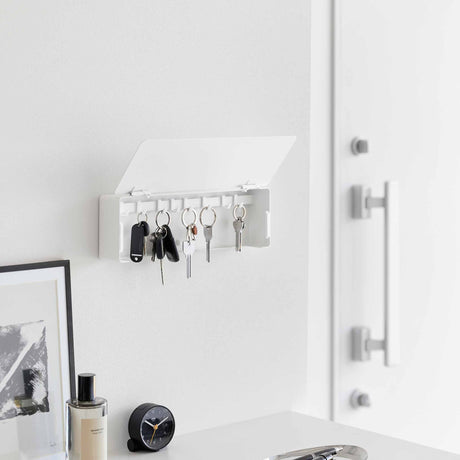 Vegghengt nøkkelskap i sort med skjult oppbevaring og flyttbare kroker