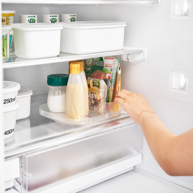 Hvit dreibar oppbevaringshylle i plast, brukt i kjøleskap for bedre organisering.