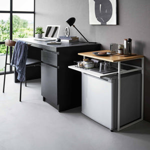 Kompakt sidebord med uttrekkbar hylle brukt som arbeidsbord ved skrivebord