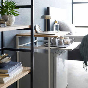 Detaljbilde av uttrekkbar hylle på sidebord med hvit stålramme