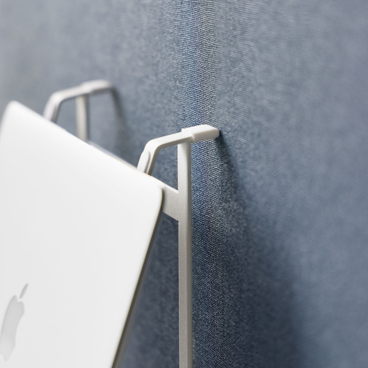 Justerbart hvitt stativ som løfter laptop for bedre ergonomi.