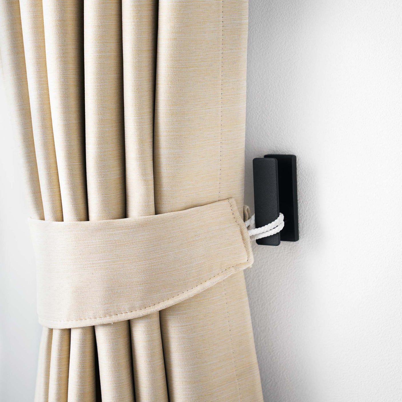 Veggmonterte sorte metallkroker brukt i entré for nøkler og vesker.