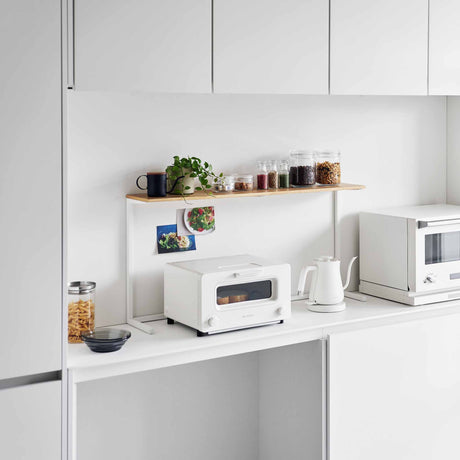 Kjøkkenhylle til benk med treplate og hvit stålramme brukt over brødrister på kjøkkenbenk