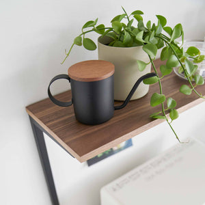 Detaljbilde av treplate på kjøkkenhylle med kopp og plante