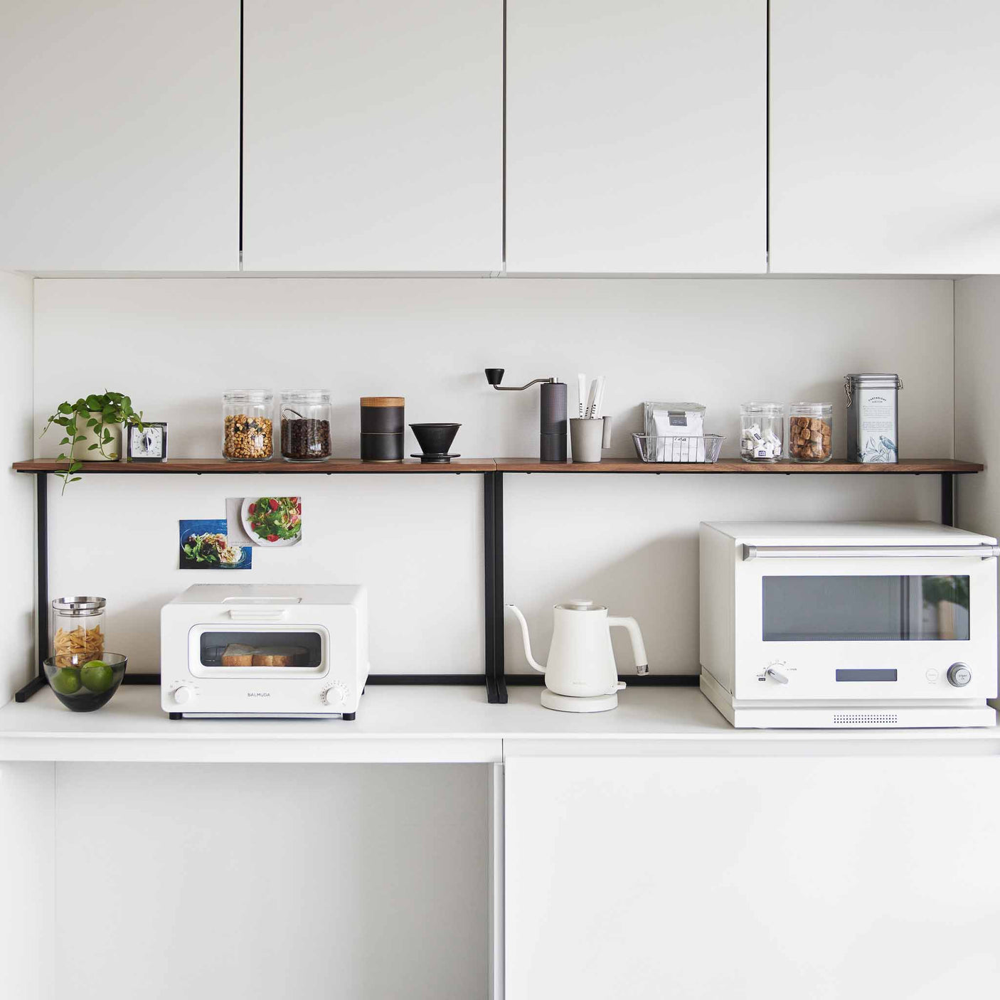 To kjøkkenhyller plassert ved siden av hverandre for ekstra oppbevaring på kjøkkenbenk