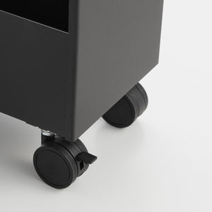 Svart oppbevaringsvogn plassert ved vaskemaskin og badekar.