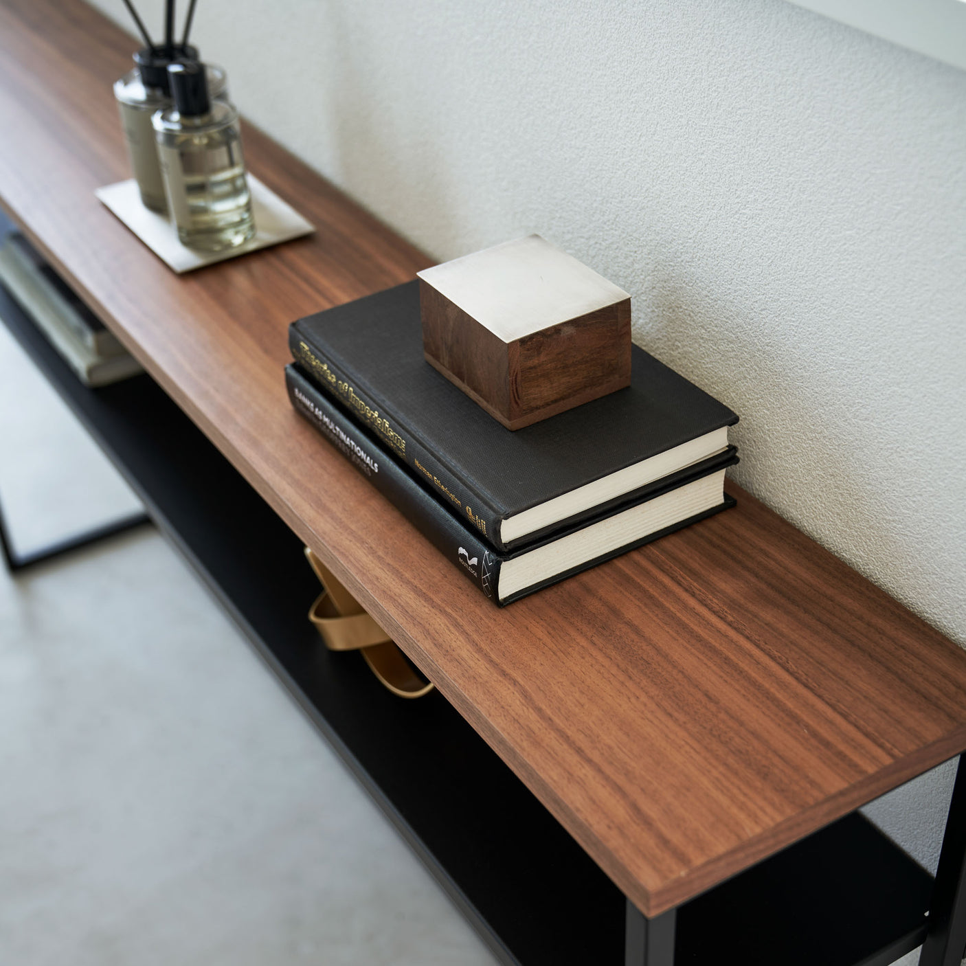 Konsollbord med sort understell og hylle under brukt til dekor.