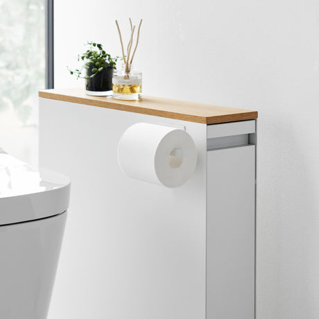 Hvit magnetisk dorullholder festet på siden av et baderomsskap.