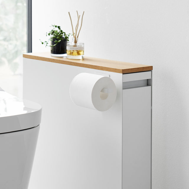 Hvit magnetisk dorullholder festet på siden av et baderomsskap.