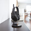 Sort hodetelefonstativ med moderne design på skrivebord.