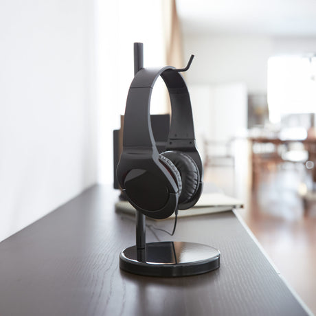 Sort hodetelefonstativ med moderne design på skrivebord.