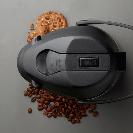 Pumpelokket från ovan med OPEN- och CLOSE-markeringer, kaffebönor bredvid