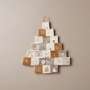 Adventskalender i stoff formet som juletre med 24 nummererte lommer, henger på vegg i varme jordtoner.