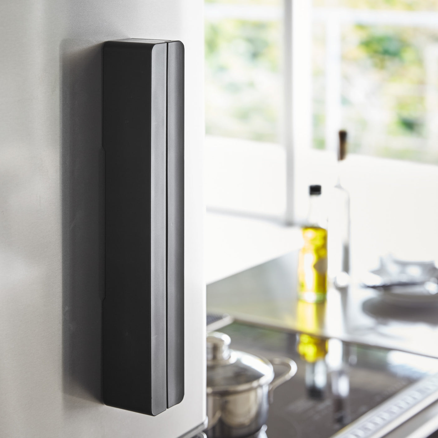 Sort folieholder med rull montert på kjøleskap.