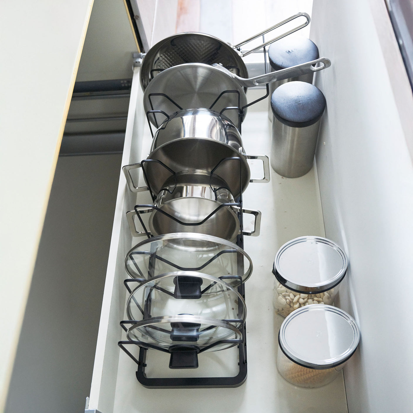 Metallholder for lokk og panner – justerbar og plassbesparende.