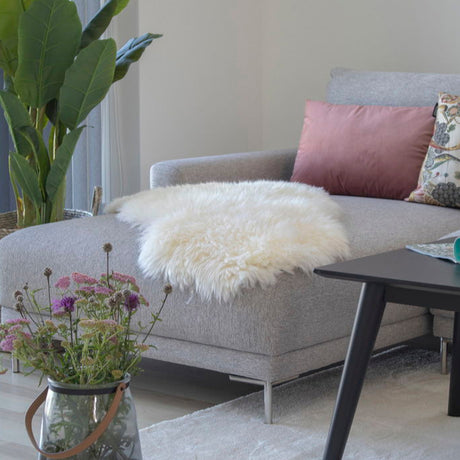 Mykt hvitt lammeskinn fra House Nordic stylet på lyse tregulv.