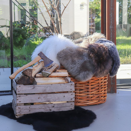 Elegant grå lammeskinn brukt på moderne stol for myk komfort.