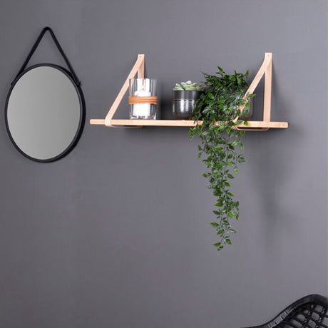 Detalj av brune skinnstropper og naturlig trestruktur