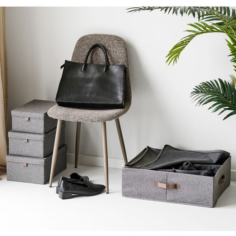 Noto oppbevaringskurv plassert på gulv med klær organisert i rommene