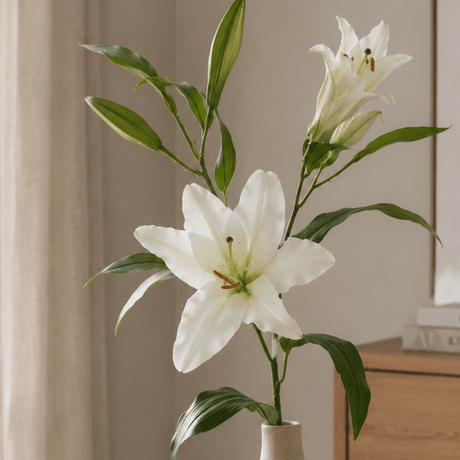 Kunstig hvit lilje med realistiske blomster og blader på grønn stilk. Nærbilde