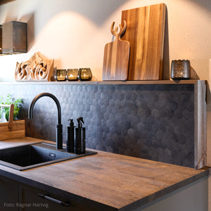 Kjøkken med mørke Hexagon fliser fra Lindas Dekor og detaljer i tre som gir et varmt, nordisk preg