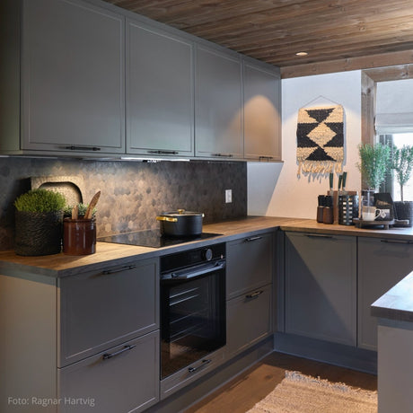 Kjøkken i Setesdal designet av Halvor Bakke med Hexagon mørk betong fliser fra Lindas Dekor og moderne, mørke fronter.