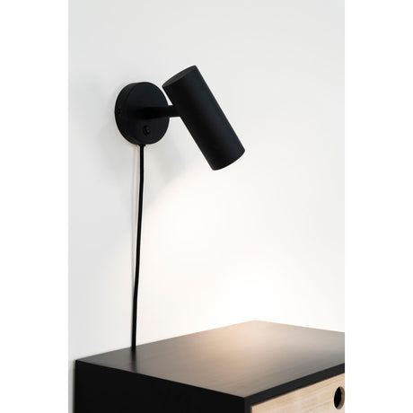 Paris vegglampe montert over nattbord i moderne soverom