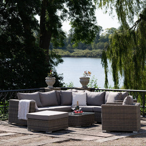 Calvi lounge set med flettet polyrattan og grå puter i hage