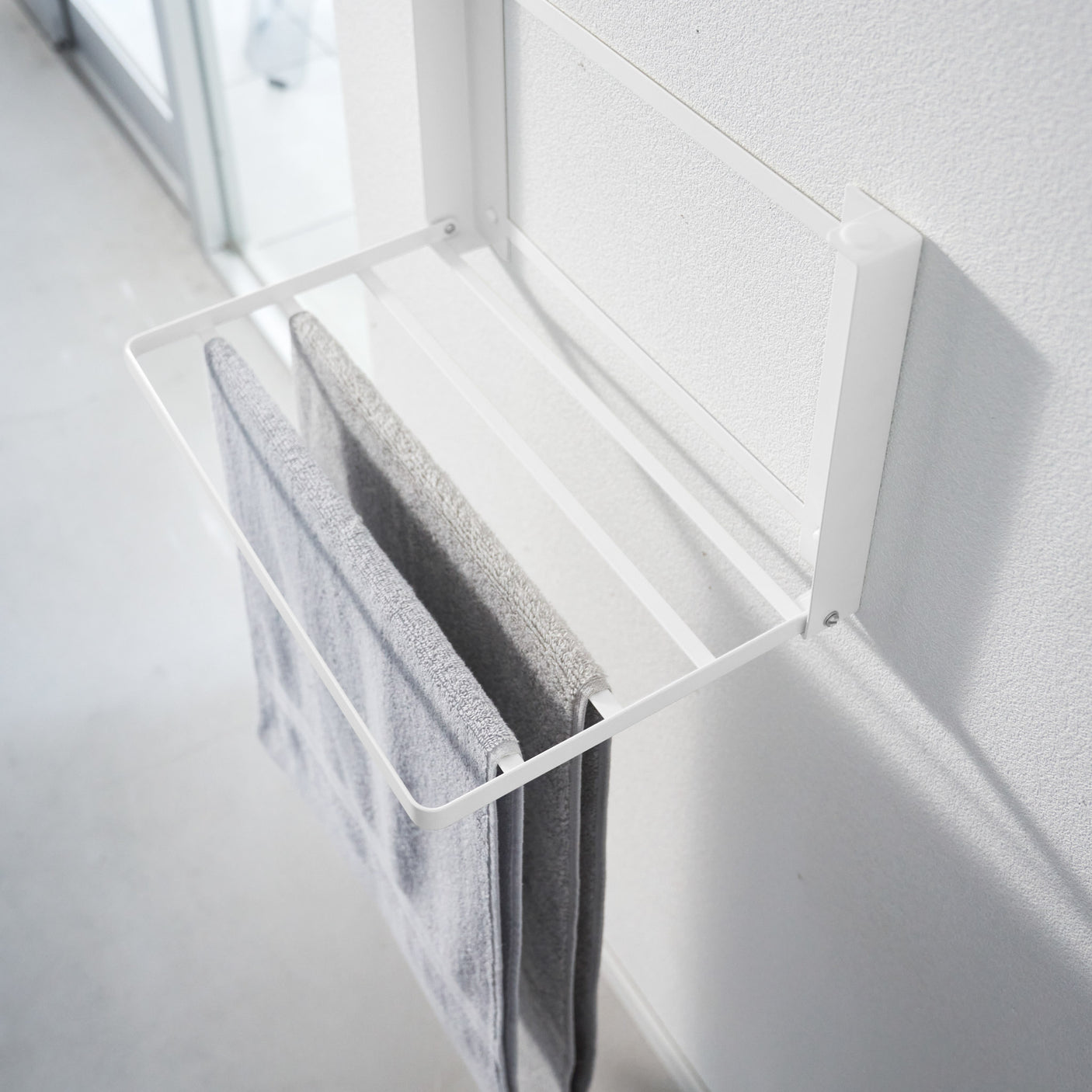 Luftig bad med hvit sammenleggbar oppbevaringshylle.