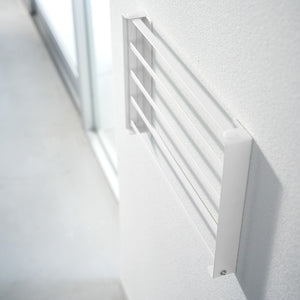 Hvit sammenleggbar hylle brukt til oppbevaring av håndklær på bad.