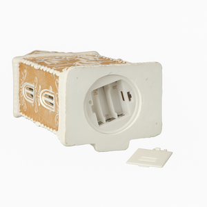 Julenisseinspirert pepperkakehus med utskårne vinduer og varm glød fra lys.