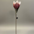 Kunstig rosa blomst med åpen kronblad på lang stilk