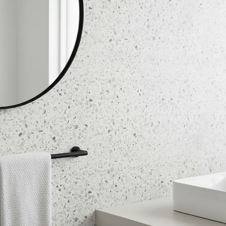 Nærbilde av Premium Granitt kontaktplast på vegg ved speil, viser granittlook og mønsterdybde
