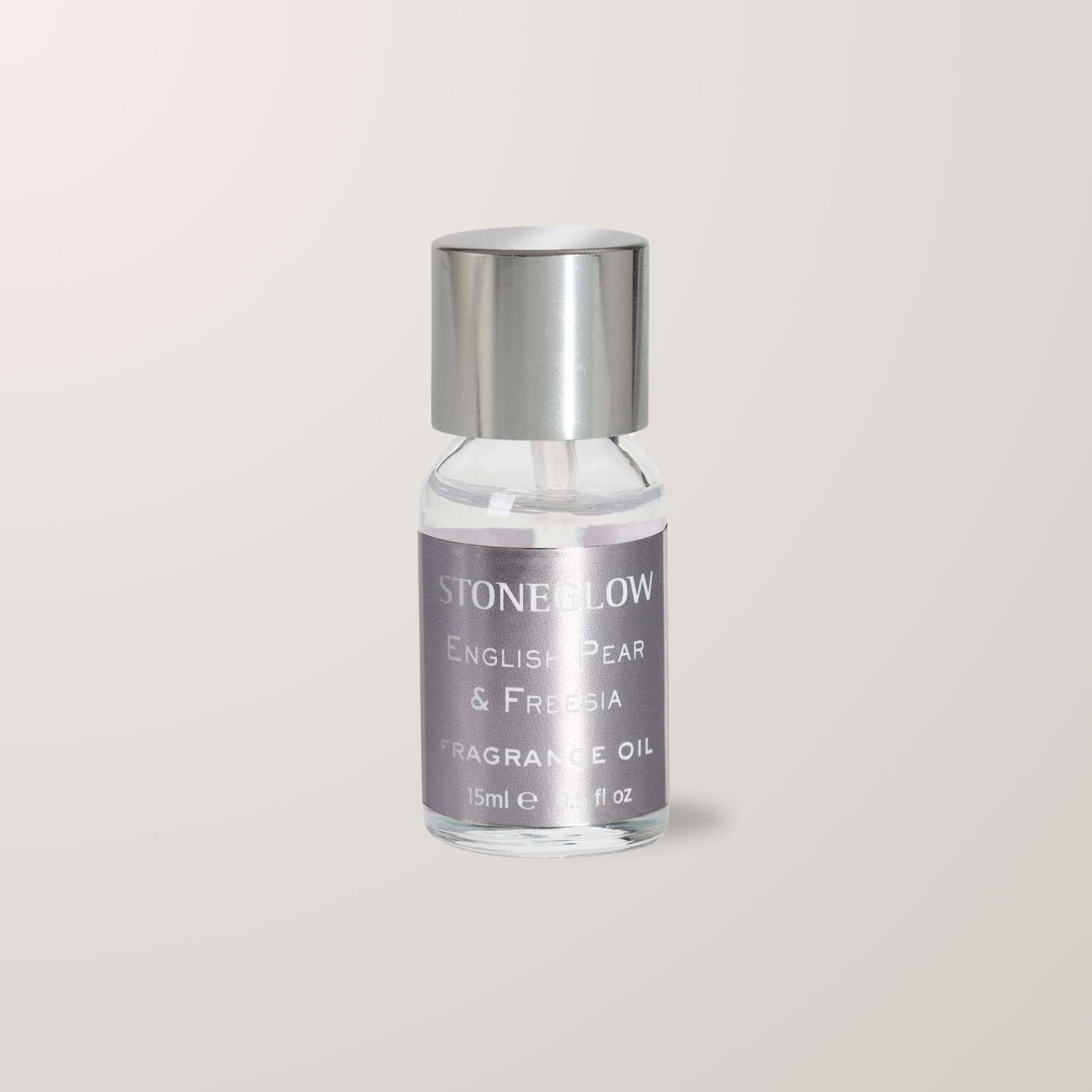Nærbilde av 15 ml Stoneglow fragrance oil med luksuriøst metallokk og grå etikett.
