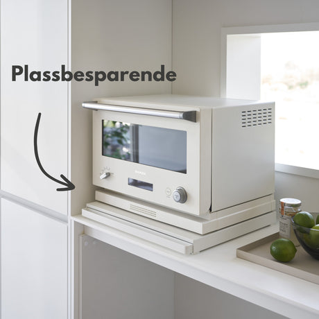 Hvitt kjøkken med uttrekkbar hylleplate under mikrobølgeovn