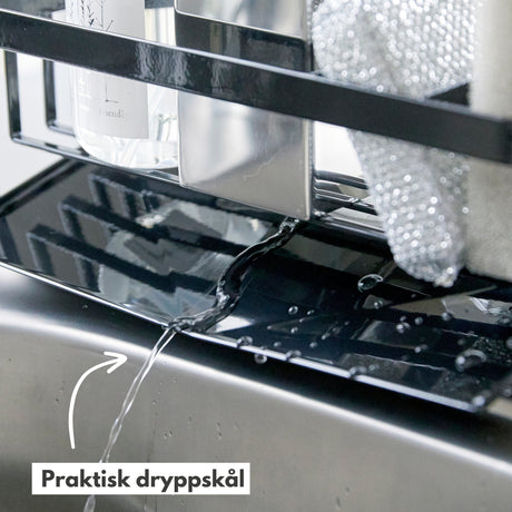 Såpeholder i bruk ved kjøkkenvask som organiserer rengjøringsartikler.