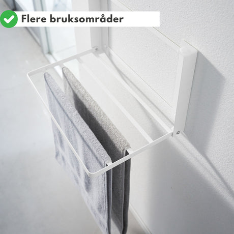 Luftig bad med hvit sammenleggbar oppbevaringshylle.