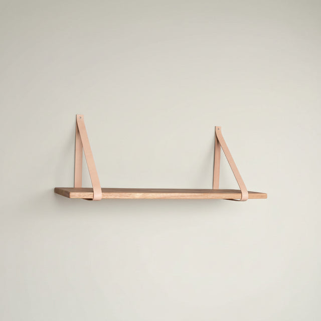 Forno vegghylle 120 cm i naturtre med brune skinnstropper montert på vegg