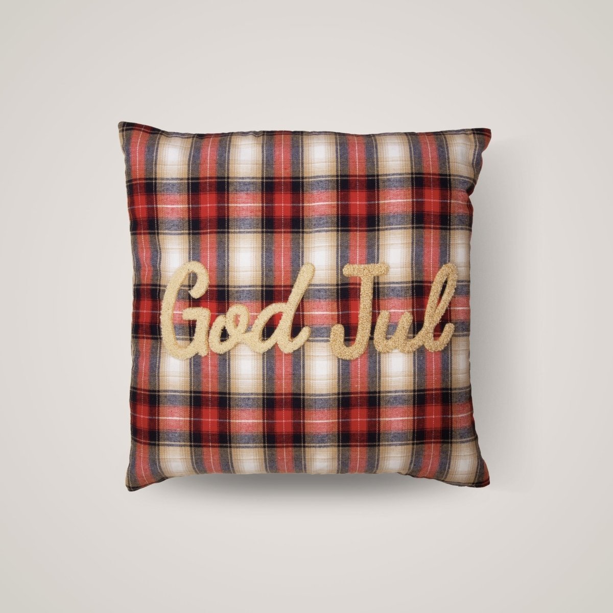 Rödrutad julstrumpa med texten "God Jul" broderad i guld på ljus bakgrund.