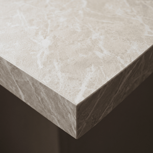 Nærbilde av benkeplatekant dekket med Limestone crema kontaktplast, kremhvit kalksteinsstruktur