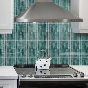 Grønne marmorfliser brukt som backsplash på kjøkken med hvite skap.