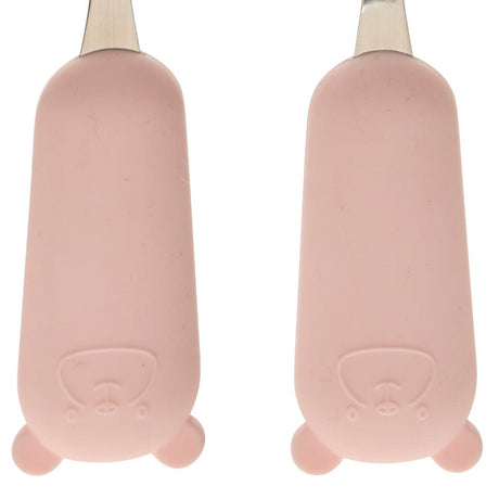 Detaljbilde av myke rosa håndtak på skje og gaffel i bestikksett for barn