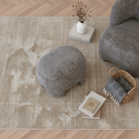 Grå puff plassert ved sofa i moderne interiør