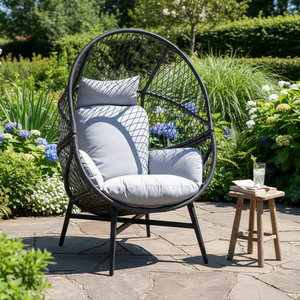 Rosario loungestol i sort polyrattan med grå puter på terrasse