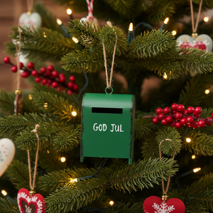 Julepynt med grön postkåsa och vit text för klassisk julstämning