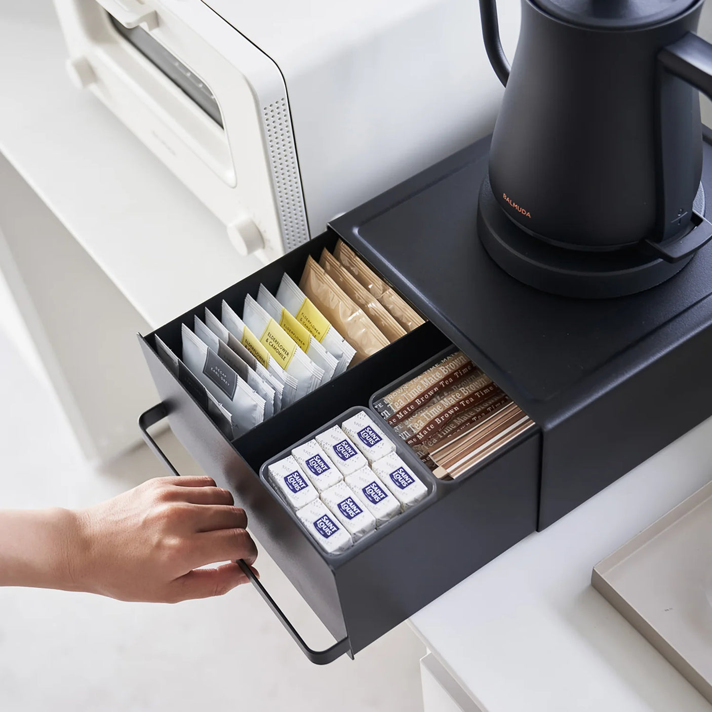 Benkeorganisator i sort med skuff for kaffeutstyr og små kjøkkenting