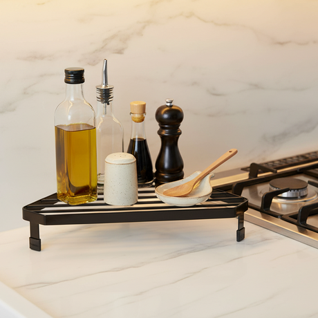 Svart kjøkkenstativ til varme panner og kokekar i hjørne