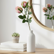 Kunstig rosa rose fra Mr. Plant i hvit vase på bord