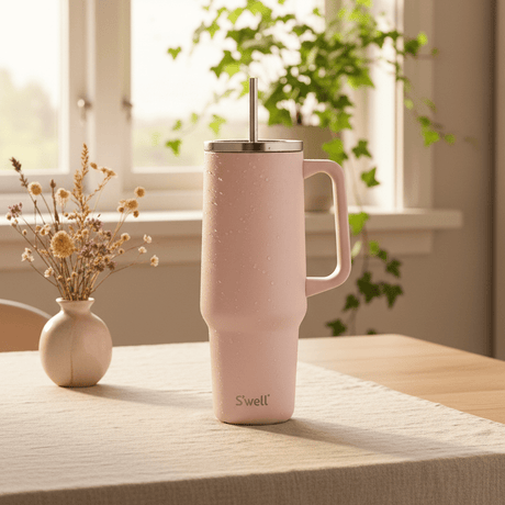 S'well termokopp i lysrosa färgen, som används som dryckemugg på köket